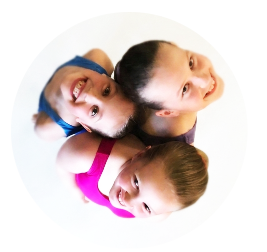 Three young ballet dancers looking up, smiling